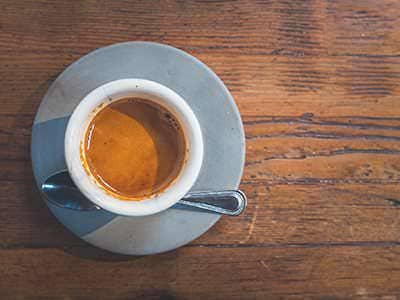Espresso in a white cup on a wooden table