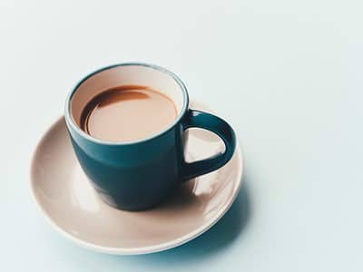 Flat white in a dark teal cup and saucer