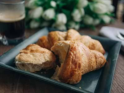 Fresh croissants on a dark plate with espresso