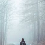 Walker with a backpack on a foggy forest road