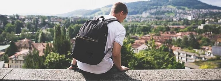 Traveller with a backpack above a town