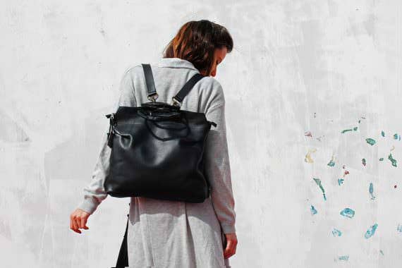 Woman with a black leather backpack
