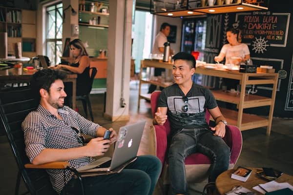 Two people talking over a laptop