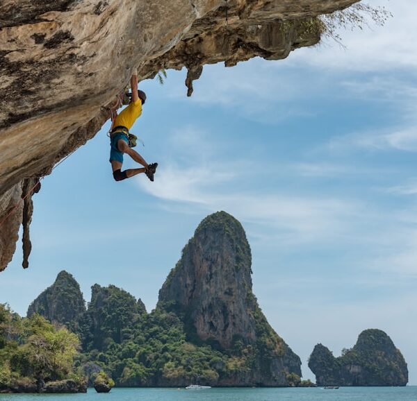 Climber on an overhanging limestone route above the sea