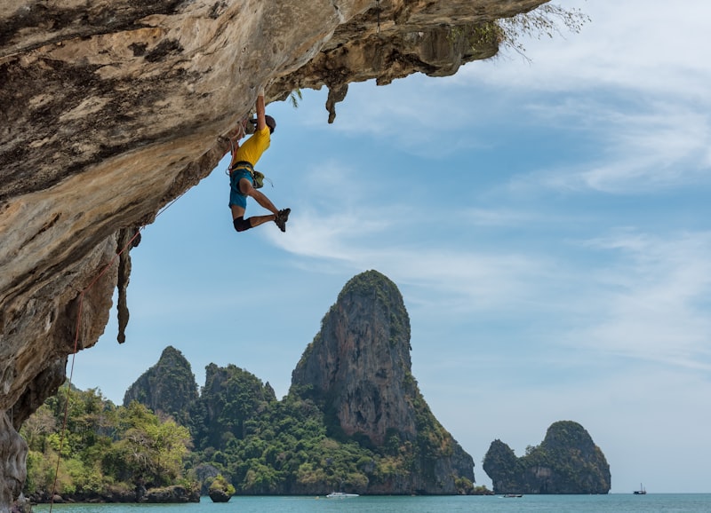 Climber on an overhanging limestone route above the sea