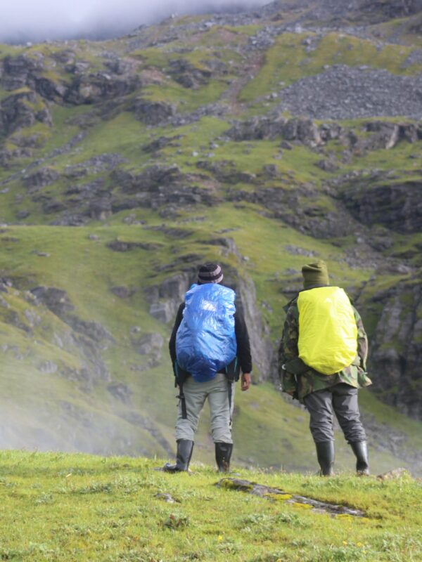 Two hikers carrying Ridge Runner packs on a green mountain trail