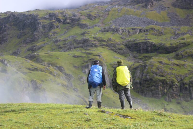Two hikers carrying Ridge Runner packs on a green mountain trail