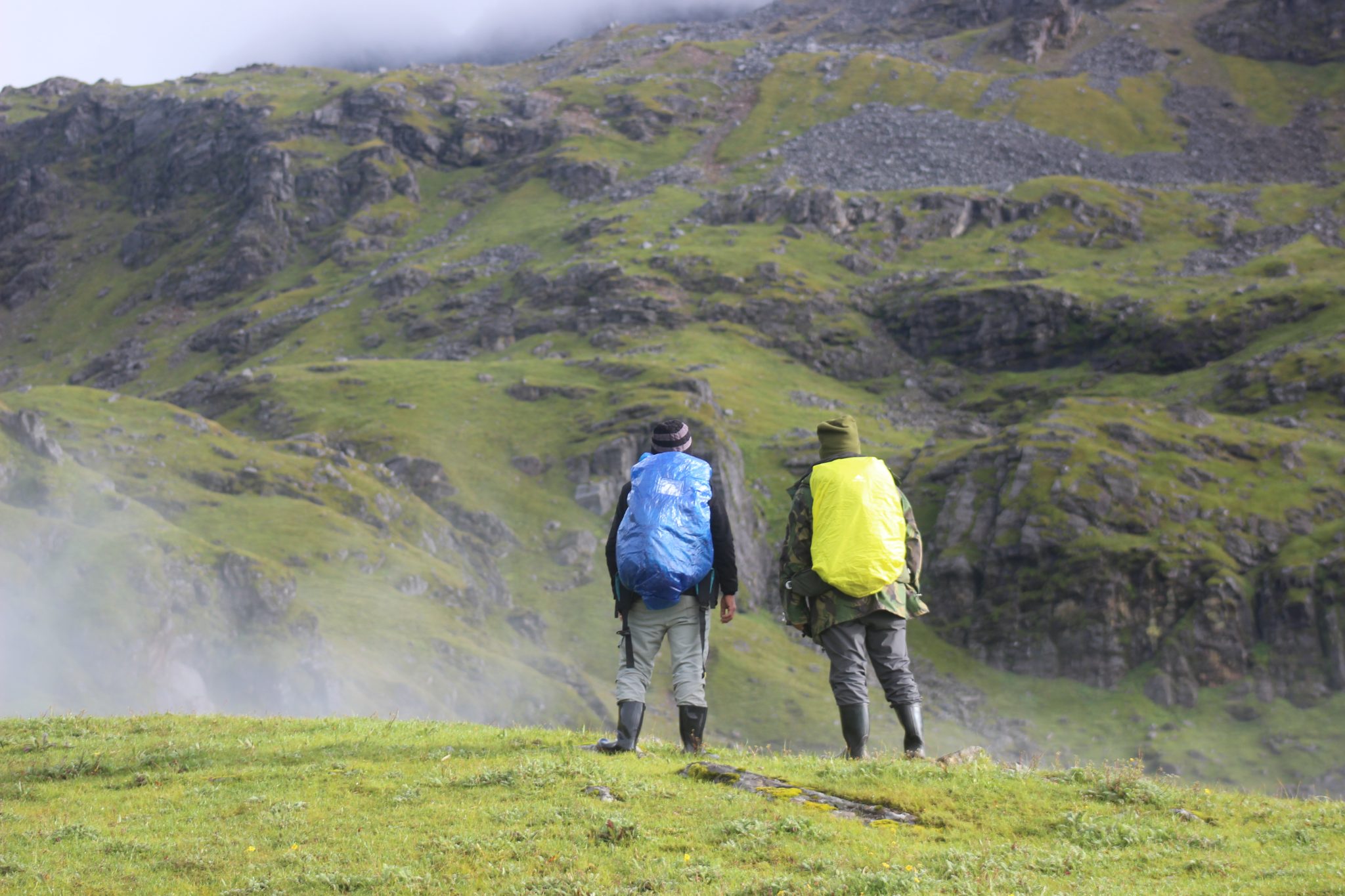 Two hikers carrying Ridge Runner packs on a green mountain trail