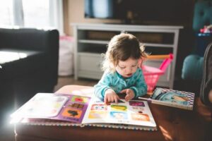 A toddler turning the pages of a picture book