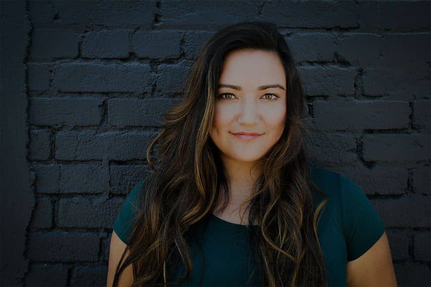 Portrait of a smiling parent against a brick wall