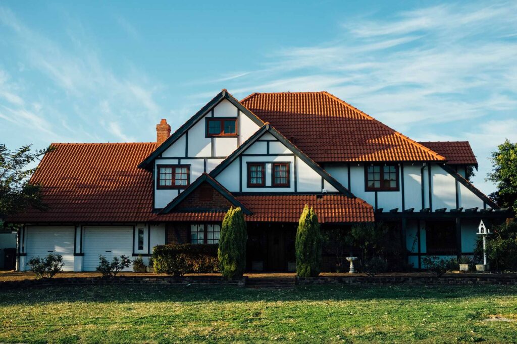 A two-story family home with a tiled roof and a front lawn