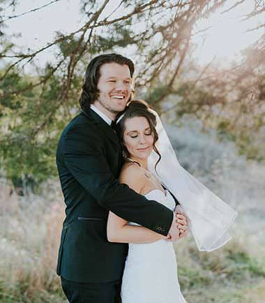 Bride and groom embracing outdoors