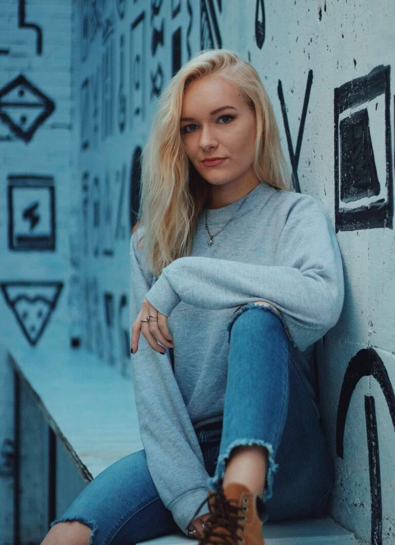 Model in denim seated in a blue tiled alcove