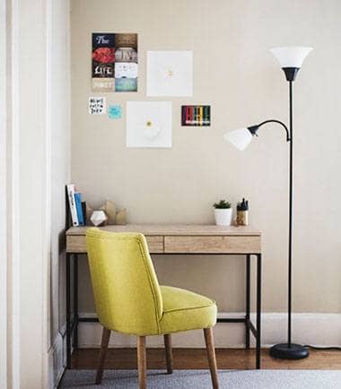 Home office corner with a yellow chair and desk lamp