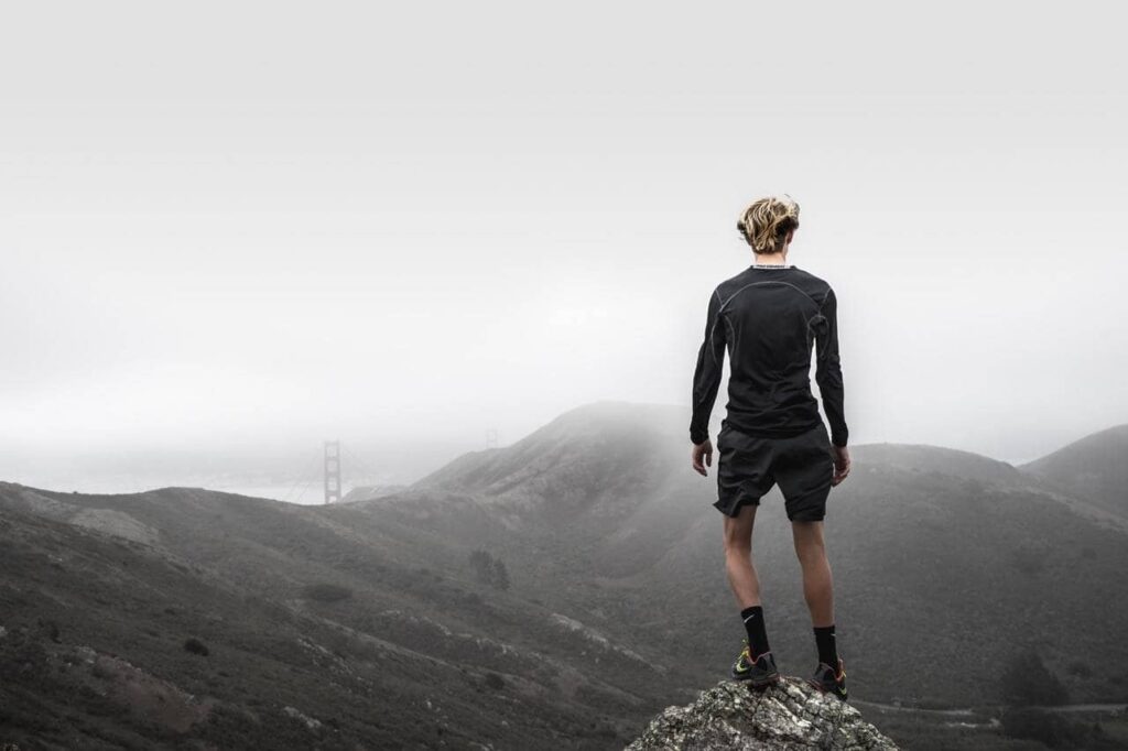 Hiker standing on a rock above a sea of cloud