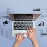 Hands at a laptop surrounded by media icons