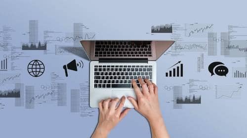 Hands at a laptop surrounded by media icons
