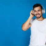 Listener wearing headphones against a blue backdrop