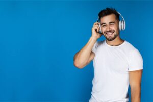 Listener wearing headphones against a blue backdrop
