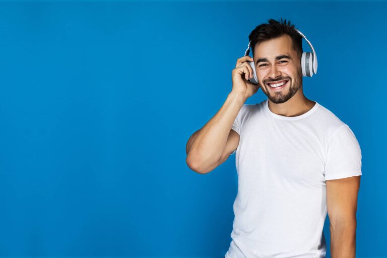 Listener wearing headphones against a blue backdrop